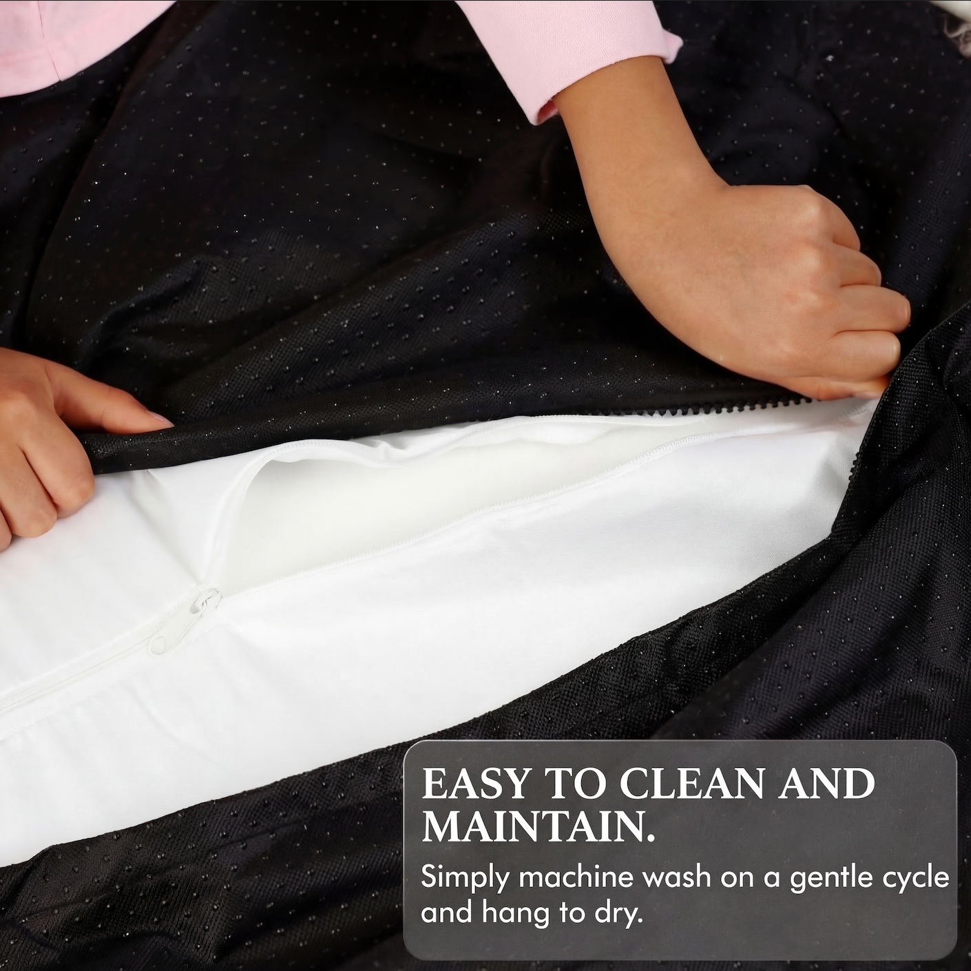 Person holding a black garment with text about cleaning and maintenance.